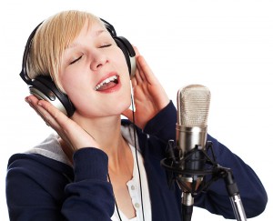 Blond Girl singing with headphones.